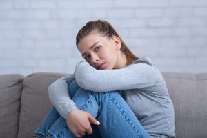 young depressed woman hugging her knees on sofa at 2022 02 04 03 06 49 utc