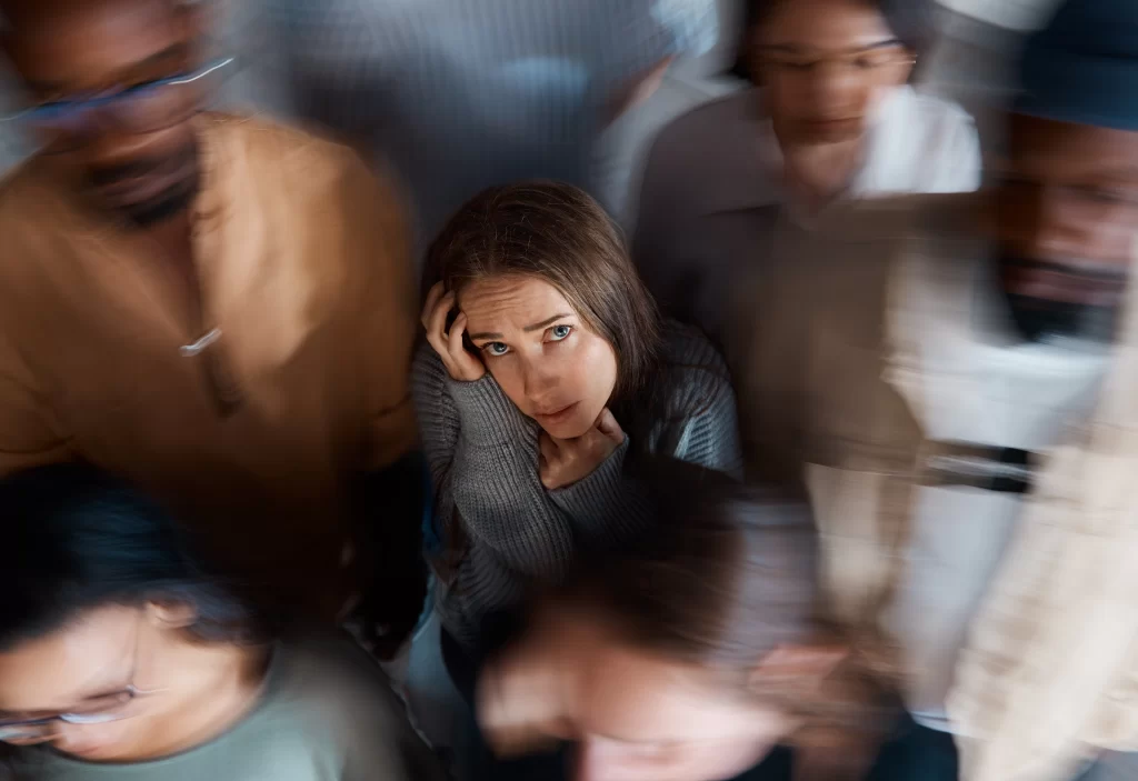alone room full people shot young woman sitting floor with people around her